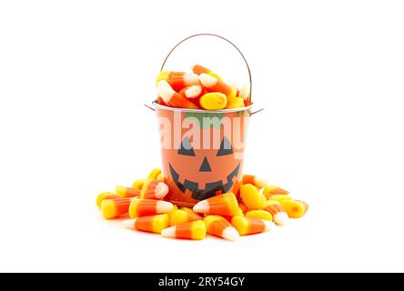 Secchiello per Lanterna Jack o TiN Pumpkin pieno di Candy Corn isolato su uno sfondo bianco Foto Stock