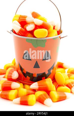 Secchiello per Lanterna Jack o TiN Pumpkin pieno di Candy Corn isolato su uno sfondo bianco Foto Stock