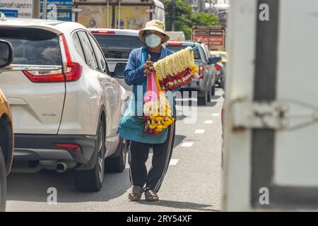 SAMUT PRAKAN, THAILANDIA, 19 settembre 2023, il venditore offre ghirlande di fiori alle auto che si trovano all'incrocio Foto Stock