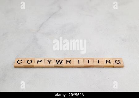 Vista dall'alto della parola copywriting su un blocco di lettere cubo di legno su sfondo bianco. Concetto aziendale Foto Stock