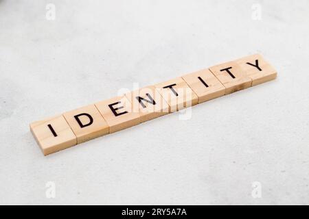 Vista dall'alto della parola identità su blocco di lettere cubo in legno su sfondo bianco. Concetto aziendale Foto Stock