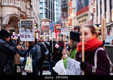 Protesta anti-pelliccia per i diritti degli animali fuori Harvey Nichols Londra 30 novembre 2013 - una folla affollata che tiene cartelli con edifici sullo sfondo Foto Stock