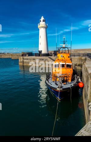 Donaghadee, County Down, Irlanda del Nord 09 marzo 2018 - la nave da salvataggio Donaghadee ormeggiata al molo e il faro di Donaghadee sullo sfondo Foto Stock