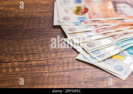 Sterlina britannica. Banconote di carta sul tavolo di legno. Foto Stock