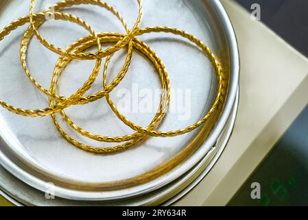 Pila di braccialetti turchi in oro turco da 24 carati su scala di gioielleria di precisione Foto Stock