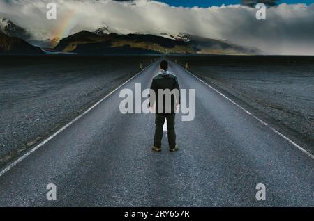 Uomo in viaggio nella natura selvaggia che guarda la montagna glaciale con l'arcobaleno Foto Stock