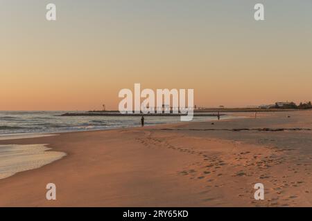 Fisherman surf casting dalla spiaggia Foto Stock