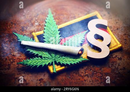 FOTOMONTAGE, Cannabisblatt-Symbol, Joint und Paragrafenzeichen auf Deutschlandfahne, Cannabisgesetz *** FOTOMONTAGGIO, simbolo della foglia di cannabis, segno di paragrafo e giunto sulla bandiera tedesca, legge sulla cannabis Foto Stock