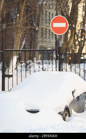 Dopo una tempesta di neve, il traffico cittadino viene fermato perché le auto sono completamente sepolte nella neve. Foto Stock