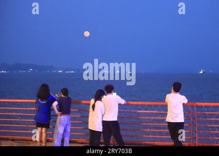 Pechino, provincia cinese di Zhejiang. 29 settembre 2023. La gente vede una luna piena sul mare di Zhoushan, provincia di Zhejiang, Cina orientale, 29 settembre 2023. Il venerdì è il festival di metà autunno di quest'anno. I cinesi hanno la tradizione di celebrare il festival ammirando la luna piena. Crediti: Xing Shoumiao/Xinhua/Alamy Live News Foto Stock