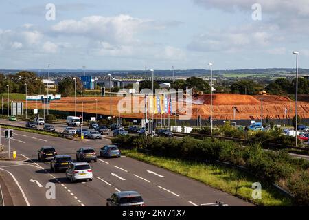 A39 di Ikea traffico stradale di giorno che mostra più corsie e nuovi cantieri di costruzione di case sullo sfondo, Exeter Foto Stock