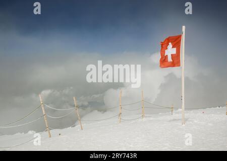 Bandiera svizzera che sventola sulle Alpi svizzere Foto Stock