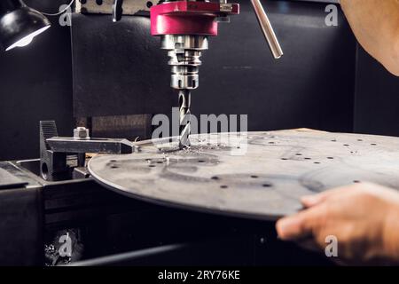 Primo piano della perforatrice per metalli. Praticare il foro del bullone inferiore. Foto Stock