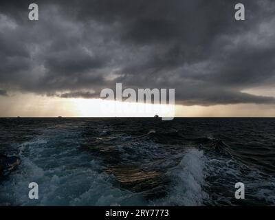 tempesta sull'oceano al tramonto Foto Stock