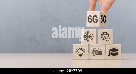 Tecnologia di rete 6G. La mano ruota il cubo di legno e cambia il segno 5G in 6G. connessione globale di rete e rete internet, reti di nuova generazione. Foto Stock