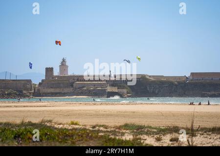 Tarifa Spagna. Piccola isola con faro, Isla de Las Palomas. Con kite surfisti, Costa de la Luz, Andalusia, Spagna. Foto Stock