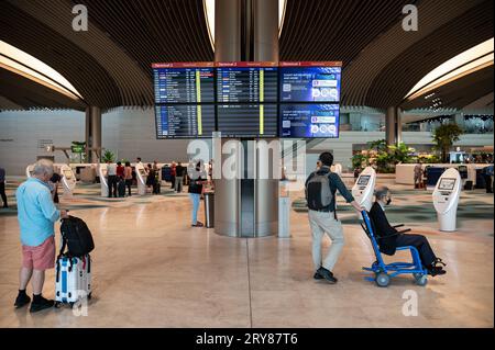 16.07.2023, Singapore, Repubblica di Singapore, Asia - i viaggiatori aerei si trovano di fronte alle schermate di informazioni sui voli nella rinnovata sala partenze T2. Foto Stock