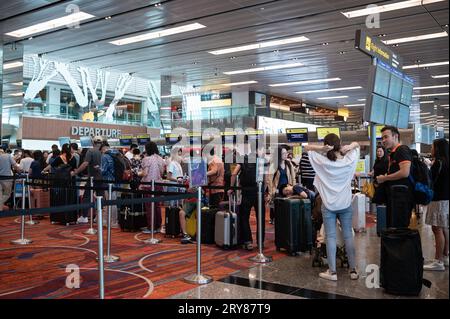 31.07.2023, Singapore, Repubblica di Singapore, Asia - i viaggiatori aerei fanno la fila per effettuare il check-in del proprio bagaglio presso un banco check-in per Scoot Airlines al T1. Foto Stock