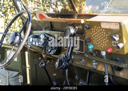 Interno di una vecchia jeep militare verde coperta da rete mimetica Foto Stock