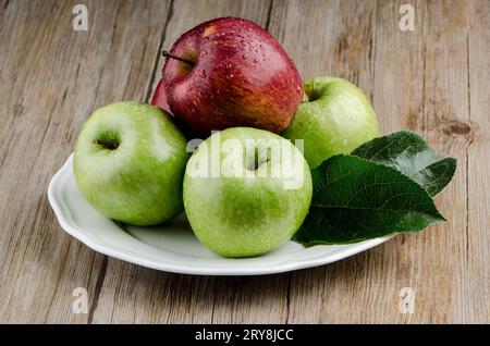 Mele in un piatto di ceramica bianca Foto Stock