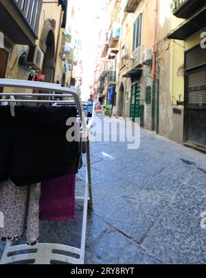 Appendere il bucato con i vestiti appesi nello stretto vicolo del quartiere napoletano chiamato quartieri spagnoli Foto Stock