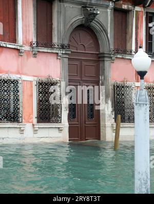Porta di una casa veneziana sommersa dall'acqua durante l'alta marea d'inverno Foto Stock