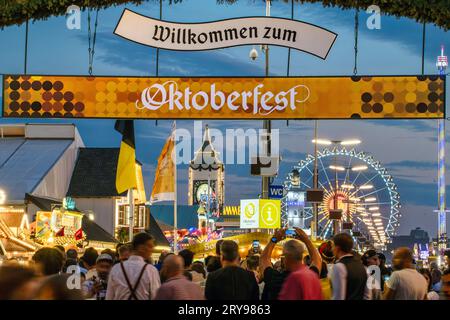 Willkommen zum Oktoberfest, Die Lichter der Fahrgeschäfte leuchten in den Abendhimmel, München, 29.09.2023 Deutschland, München, settembre 2023, Willkommen zum Oktoberfest, viele Besucher strömen abends auf die Festwiese, Wiesnbummel am Freitagabend um 19:15 Uhr, Dämmerung, Blaue Stunde, bestes Wiesnwetter, blauer Himmel, sonnig, wärmste Wiesn aller Zeiten, Volksfest, bayerisch, bayern, *** Benvenuti all'Oktoberfest, le luci delle giostre brillano nel cielo serale, Monaco di Baviera, 29 09 2023 Germania, Monaco di Baviera, settembre 2023, Benvenuti all'Oktoberfest, molti visitatori affollano il Festwiese in pari Foto Stock