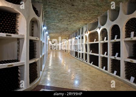 Bottiglie di vino conservate presso le antiche gallerie sotterranee di pietra calcarea della cantina Cricova a Cricova, Moldavia Foto Stock