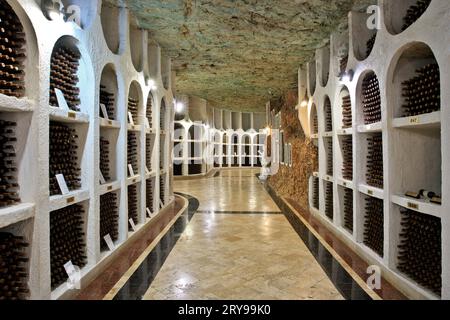 Bottiglie di vino conservate presso le antiche gallerie sotterranee di pietra calcarea della cantina Cricova a Cricova, Moldavia Foto Stock