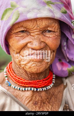 Una donna anziana dei boscimani del Kalahari centrale, nel villaggio di New Xade in Botswana, nel cortile della sua casa Foto Stock