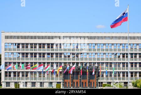 Lubiana, L, Slovenia - 15 agosto 2023: Edificio del Parlamento sloveno della capitale europea e bandiera sventolante Foto Stock