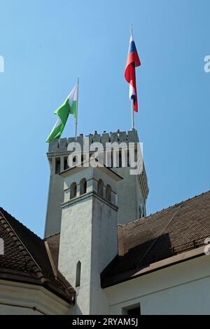 Lubiana, L, Slovenia - 15 agosto 2023: Torre dell'antico castello chiamato ljubljanski grad in lingua slovena e bandiere Foto Stock