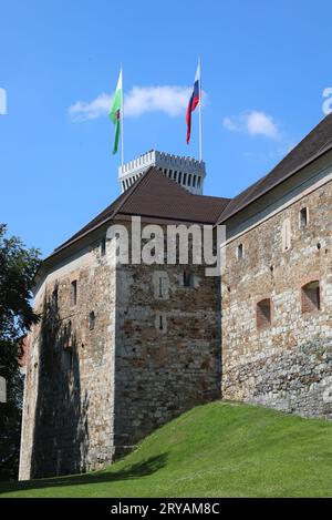 Lubiana, L, Slovenia - 15 agosto 2023: Torre dell'antico castello chiamato ljubljanski grad in lingua slovena e bandiere Foto Stock