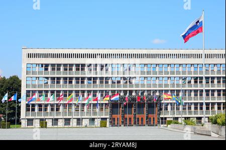 Lubiana, L, Slovenia - 15 agosto 2023: Edificio del Parlamento sloveno della capitale europea e grande bandiera Foto Stock