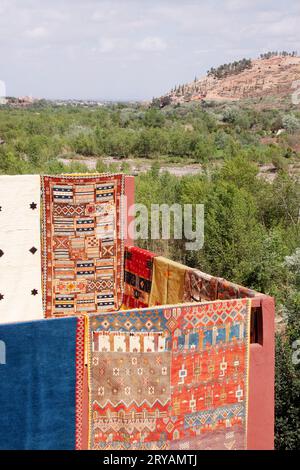 Tappeti appesi contro la cima della montagna del villaggio berbero in Marocco, marzo 2012 Foto Stock