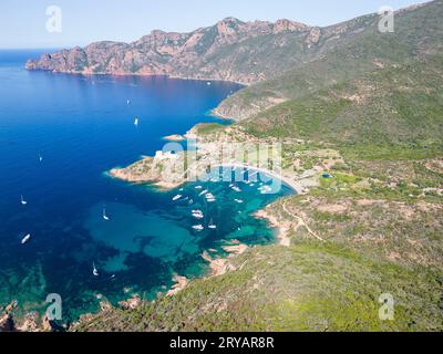 Vista aerea con droni di Port de Girolata e della sua costa, un remoto villaggio sull'isola della Corsica, Francia, Europa. Foto Stock