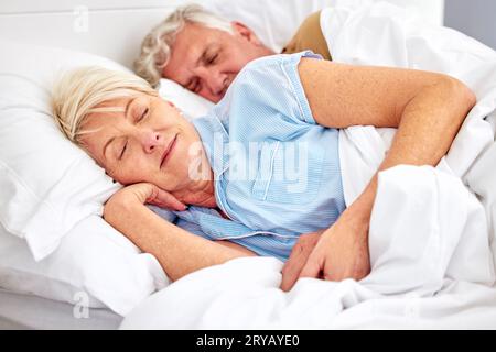 Dormire, camera da letto e coppia anziana con amore, rilassarsi e ritirarsi in un weekend di pausa, riposare e calma. Pace, anziana o anziana in un letto Foto Stock