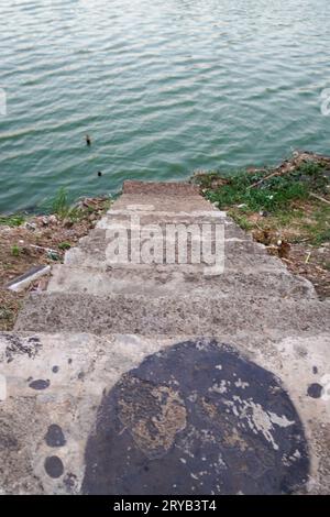 I gradini che conducono al lago sono fatti di cemento con terreno rosso intorno ad esso. visto dall'alto. Foto Stock