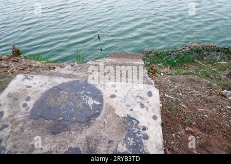 I gradini che conducono al lago sono fatti di cemento con terreno rosso intorno ad esso. visto dall'alto. Foto Stock