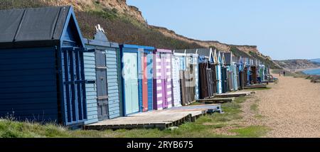 Barton on Sea, Hampshire, Inghilterra, Regno Unito - mostra una fila di capanne sulla spiaggia. Foto Stock