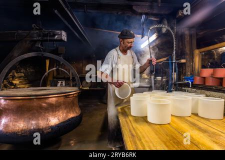 In estate, i visitatori del caseificio alpino Moléson-sur-Gruyères possono sperimentare come viene prodotto il formaggio. Moléson nel cantone di Friburgo, Svizzera Foto Stock