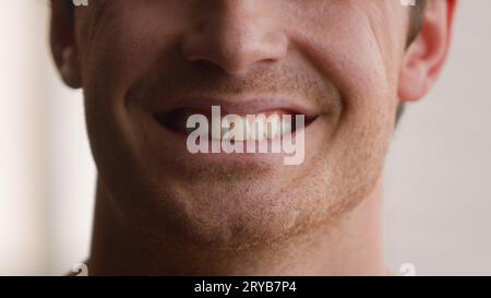 Vista ritagliata irriconoscibile uomo caucasico sorriso denti maschili sorridente felice gioioso spensierato ragazzo casa clinica medica ortodontica orale Foto Stock