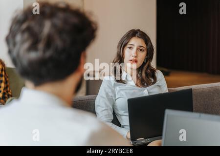 Vista del profilo di un giovane uomo in sedia a rotelle che lavora su un computer portatile in un bar Foto Stock