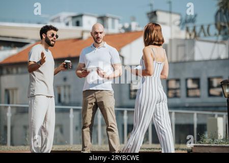 Un gruppo di professionisti collabora all'aperto, discutendo di progetti e schizzi per una progettazione di edifici moderni. Questo team di successo è un esempio di eccellenza Foto Stock