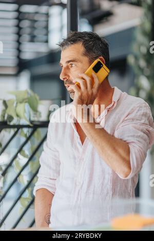 Un uomo d'affari che si prende una pausa dal lavoro. Sta facendo una telefonata. Foto Stock