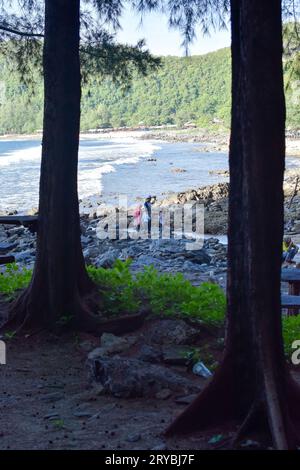 Aceh, Indonesia - settembre 2023: Persone non identificate sulla spiaggia e rocce sulla spiaggia di sera Foto Stock