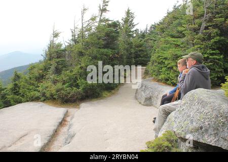 Vecchio e giovane ragazzo riposano su un sentiero di montagna (gli escursionisti riposano) Foto Stock