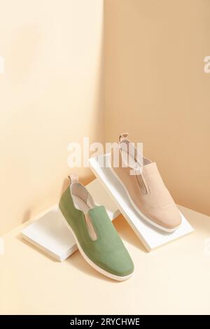 Sneaker eleganti in colori naturali isolate su sfondo beige; spazio per il testo; vista in prospettiva Foto Stock