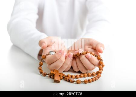 Le mani dei bambini offrono perline di rosario in legno Foto Stock