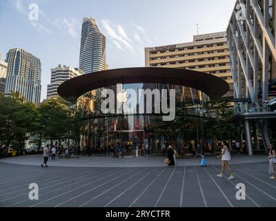 Un Apple store a Bangkok, Thailandia, che presenta riflessi sulla sua facciata di vetro mentre la gente passeggia nelle vicinanze. Foto Stock